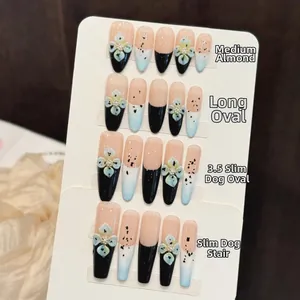 Detail of handmade press-on nails with 3D floral art, black French tips and pearl accents