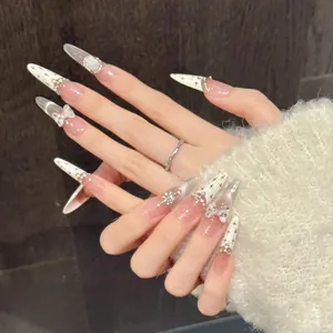 Detail of cream white French press-on nails with 3D bows, pearls, and silver stars