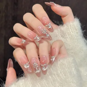 Macro detail of peach cat-eye press-on nails with silver glitter and pearl accents