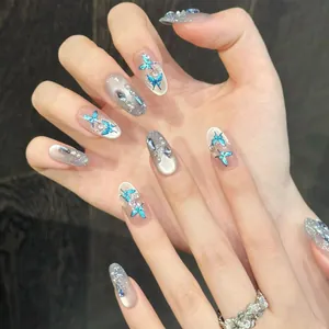 Close-up of blue butterfly nail art with silver cat eye finish and pearl accents