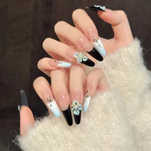 Detail of stiletto press-on nails with 3D blue flowers and black gradient splatter
