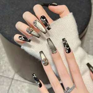 Detailansicht handgefertigter Katzenaugen-Kunstnägel mit Glitzersteinen und Edelsteinen