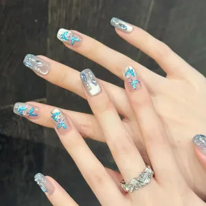Detail of blue butterfly press-on nails with silver glitter gradient and rhinestones