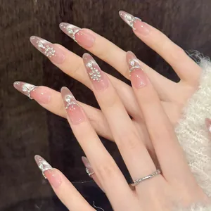 Macro detail of almond press-on nails with pink gradient, pearls and crystals