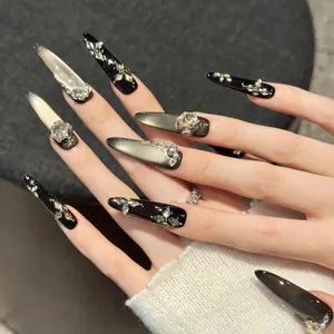 Detail von langen Stiletto-Klebenägeln mit silbernem Cat-Eye-Effekt und Straßblumen