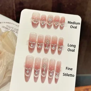 Peach pink cat eye press-on nails set with rhinestones in oval and stiletto shapes