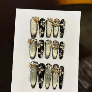 Dunkelgraue Katzenaugen-Press-on-Nägel mit champagnergoldenen Sternen und Perlen