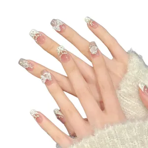 Handmade creamy white bow press-on nails with french tip pearls and rhinestone accents