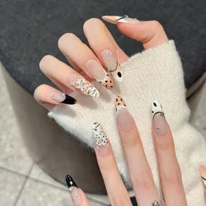 Detail of handmade almond nails with leopard patterns and 3D butterfly accents