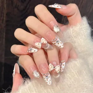 Macro view of almond press-on nails featuring 3D bows, pearls, and cat-eye finish