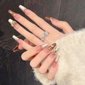 Détail de faux ongles oeil de chat faits main avec dégradé ambre et strass de luxe