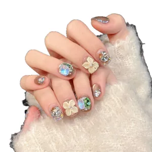 Handgemachte 3D-Blumen-Nägel mit blauen Kristallen und braunem Katzenaugen-Effekt