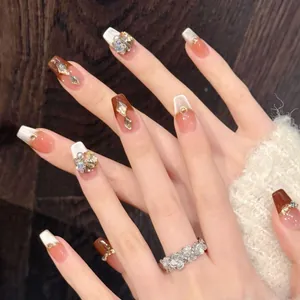 Détails macro de faux ongles faits main avec effet œil de chat ambre et strass de luxe