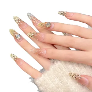 Elegant almond press-on nails with nude pink gradient, rhinestones, and pearls