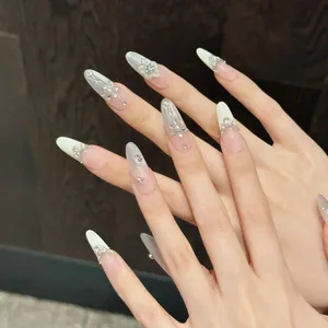 Detail of handmade press-on nails with 3D white flowers, pearls and radiant rhinestones