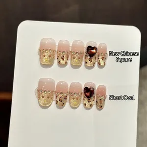 Handmade leopard print press-on nails with red heart gem and glittering rhinestones