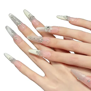 Long stiletto press-on nails with pink-white gradient cat eye effect and rhinestones