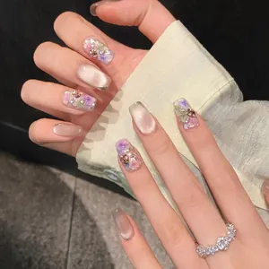 Vista dettagliata delle unghie press-on floreali con effetto cat eye e strass perla