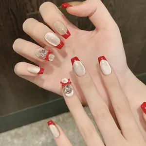 Détails de faux ongles faits main avec bordures rouges françaises et nœuds en 3D