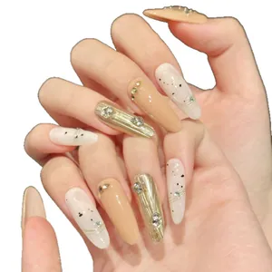 Faux ongles longs amande avec texture dorée, strass et finition nude élégante