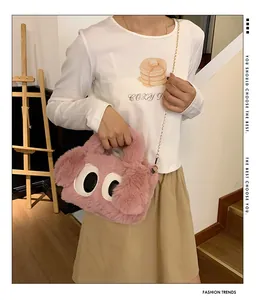 Sac à bandoulière en peluche rose avec de grands yeux porté par un mannequin en intérieur