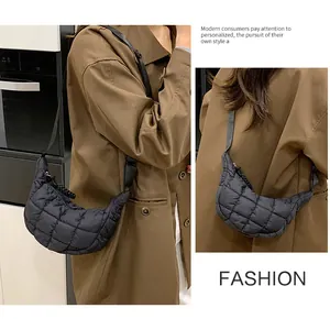 Detail of black quilted puffer crescent bag featuring soft padded texture and strap