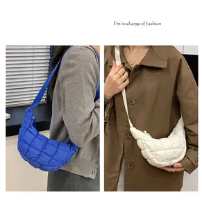 Quilted crossbody bag detail featuring royal blue and beige puffy padded fabric textures