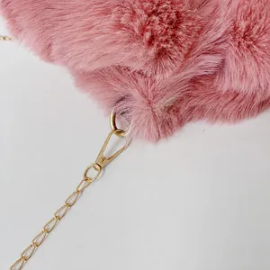 Détail du sac en peluche rose avec chaîne en métal doré amovible et fermoir mousqueton