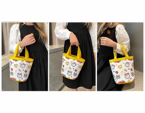 Detail of white canvas bucket bag with yellow handles and cute rabbit patterns