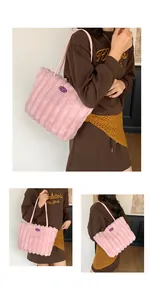 Detail view of pink plush tote bag with vertical stripes and purple label on side