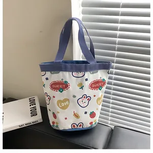 Detail of canvas bucket bag with cute bunny print and blue handles on a cozy background