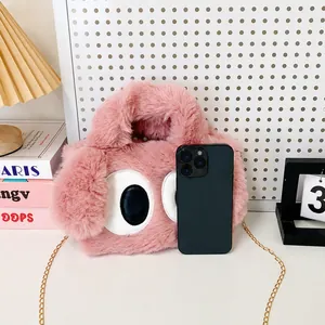 Sac à main rose en peluche avec grands yeux de dessin animé, taille comparée à un téléphone
