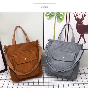 Detailed view of corduroy tote bags in brown and gray with front pockets and buttons