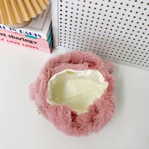 Gros plan du sac à main en peluche rose montrant la doublure blanche et le fermoir aimanté