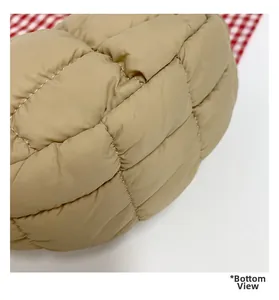 Detailed macro view of the khaki quilted puff bag showing clean stitching and soft texture