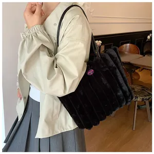 Detailed view of black faux fur tote bag with vertical pleats and fashion embroidery