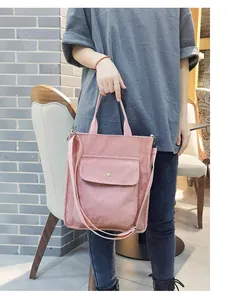 Detailed view of pink corduroy tote bag with adjustable strap and front flap pocket