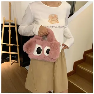 Gros plan du sac en peluche rose avec yeux de chiot et bandoulière en chaîne dorée
