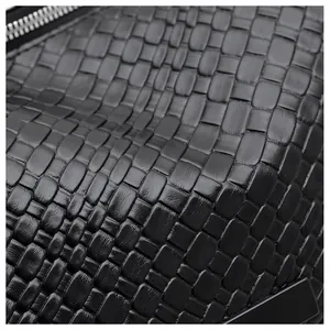 Vue macro de la texture en cuir tissé noir et détails du zip argenté sur le sac