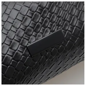 Gros plan sur la texture tissée noire et l'élégante boucle rectangulaire du sac à main