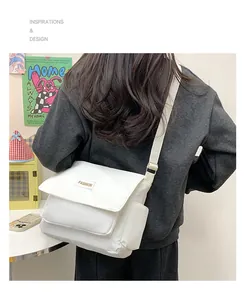 Dettaglio della borsa a tracolla in tela bianca con etichetta fashion sulla modella