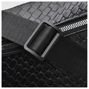 Vue rapprochée de la texture cuir croco noir avec détail de fermeture éclair en métal