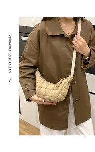 Versatile beige quilted cloud crossbody bag with braided zipper detail on model