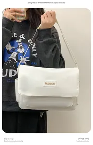 Dettaglio della borsa a tracolla in tela bianca con cinturino regolabile e logo moda