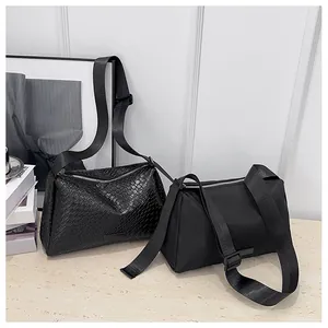 Détail de sacs à bandoulière noirs tissés et lisses avec sangles en nylon réglables