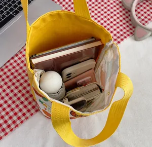 Intérieur spacieux du sac en toile jaune montrant un ordinateur, des livres et objets