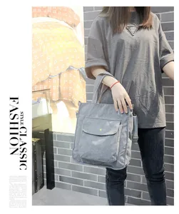 Close-up of light blue corduroy shoulder bag with front flap pocket and adjustable strap
