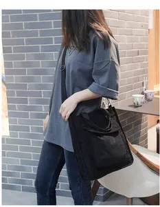 Detail view of large black corduroy tote bag with adjustable shoulder strap and outer pocket