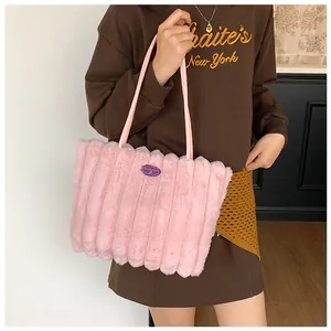 Close-up of pink plush tote bag featuring vertical quilted texture and embroidery