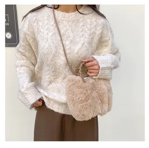 Gros plan du sac en fausse fourrure avec poignée tressée sur pull en maille blanc
